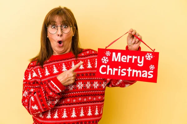 Middle Age Caucasian Woman Holding Merry Christmas Placard Isolated Yellow — Stock Photo, Image