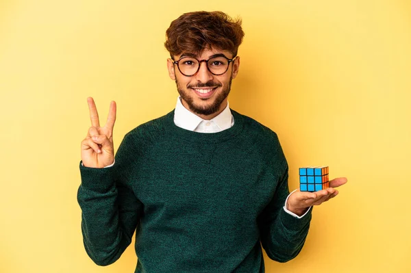 Mladý Smíšené Rasy Muž Drží Rubiks Kostka Izolované Žlutém Pozadí — Stock fotografie