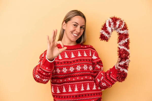 Junge Kaukasische Frau Hält Großen Weihnachtsstock Isoliert Auf Gelbem Hintergrund — Stockfoto