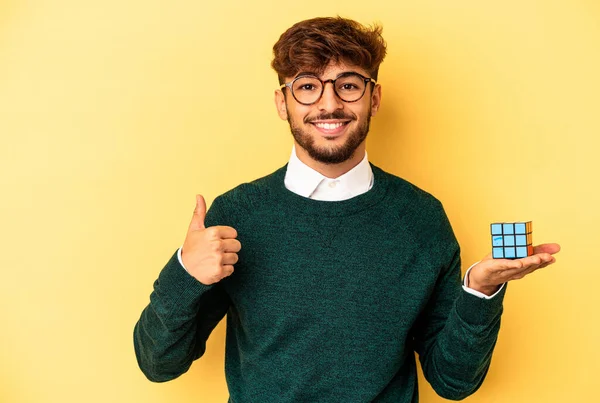 Mladý Smíšené Rasy Muž Drží Rubiks Kostka Izolované Žlutém Pozadí — Stock fotografie