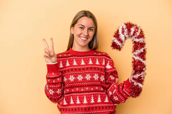 Junge Kaukasische Frau Hält Großen Weihnachtsstock Auf Gelbem Hintergrund Und — Stockfoto