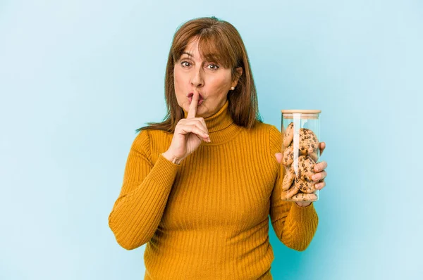 Middle Age Caucasian Woman Holding Cookies Jar Isolated Blue Background — Stockfoto