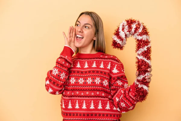 Sarı Arka Planda Izole Edilmiş Büyük Bir Noel Sopası Tutan — Stok fotoğraf