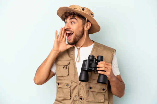 Young Mixed Race Man Holding Binoculars Isolated Blue Background Shouting — 图库照片