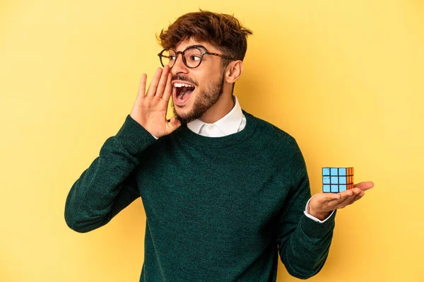 Mladý Smíšený Závod Muž Drží Rubiks Kostky Izolované Žlutém Pozadí — Stock fotografie