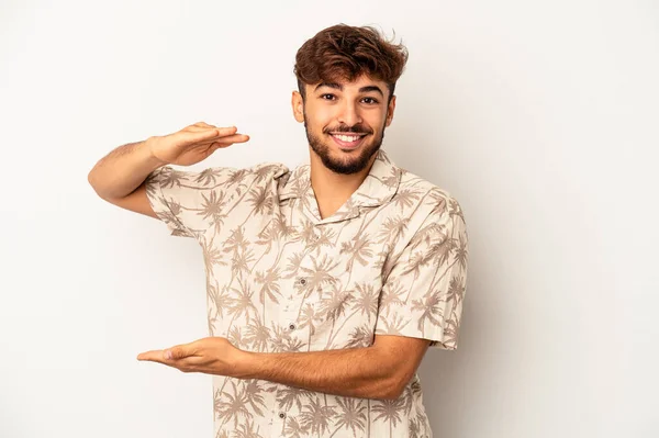 Young Mixed Race Man Isolated Grey Background Holding Something Little — стоковое фото