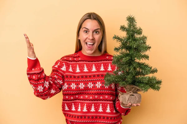 Young Caucasian Woman Holding Little Christmas Tree Isolated Yellow Background — Stock Photo, Image