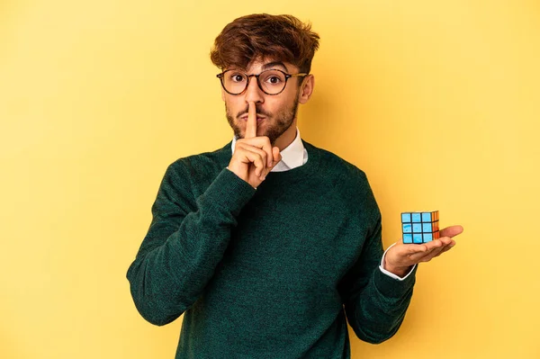 Mladý Smíšené Rasy Muž Drží Rubiks Kostky Izolované Žlutém Pozadí — Stock fotografie