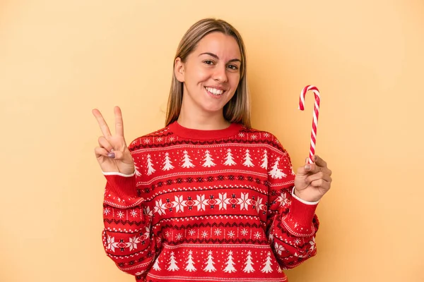 Jovem Caucasiana Segurando Pau Natal Isolado Fundo Amarelo Mostrando Número — Fotografia de Stock