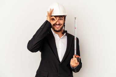 Miğfer takan ve taksimetre tutan genç bir mimar gri arka planda heyecanlı..