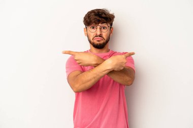 Gri arka plan noktalarında izole edilmiş genç melez, iki seçenek arasında seçim yapmaya çalışıyor..