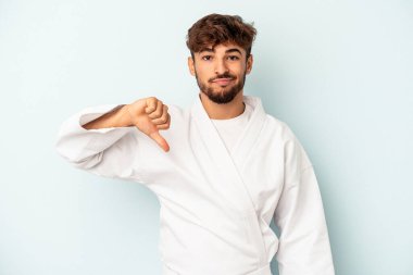 Mavi arka planda karate yapan genç melez adam hoşlanmadığı bir hareket gösteriyor. Anlaşmazlık konsepti.