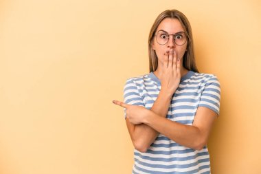 Sarı arka planda izole edilmiş genç, beyaz bir kadın.