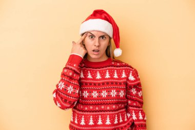 Sarı arka planda izole edilmiş bir şekilde Noel 'i kutlayan beyaz bir kadın işaret parmağıyla yaptığı hayal kırıklığı jestini gösteriyor..