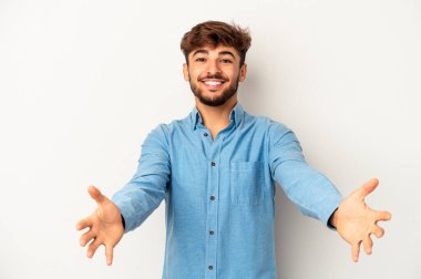 Genç melez adam gri arka planda izole edilmiş hoş bir ifade sergiliyor..