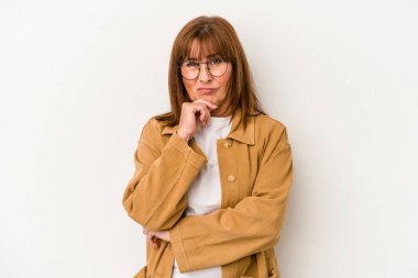 Beyaz arka planda soyutlanmış orta yaşlı beyaz bir kadın. Düşünüyor, bakıyor, yansıtıyor, düşünüyor, bir fantezi kuruyor..