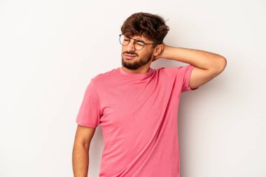 Genç melez adam gri arka planda izole edilmiş. Çok yorgun ve uykulu. Elini başının üstünde tutuyor..