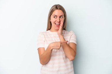 Kafkasyalı genç bir kadın mavi arka planda izole edilmiş. Dedikodu yapıyor, bir şeyleri bildiriyor..