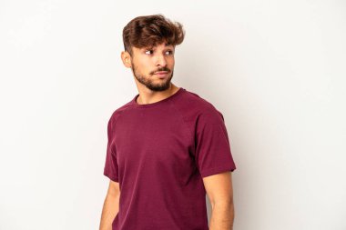 Gri arka planda soyutlanmış genç bir ırk. Gülümsüyor, neşeli ve keyifli görünüyor..