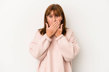 Beyaz arka planda izole edilmiş orta yaşlı beyaz bir kadın ağzı kapalı ve elleri endişeli görünüyor..