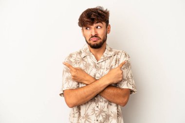 Gri arka plan noktalarında izole edilmiş genç melez, iki seçenek arasında seçim yapmaya çalışıyor..