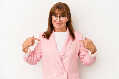 Beyaz arka planda izole edilmiş orta yaşlı beyaz bir kadın gömlek fotokopi odasını işaret ediyor, gururlu ve kendinden emin.