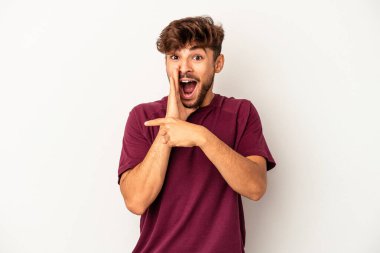 Genç melez adam gri arka planda izole edilmiş. Dedikodu yapıyor, bir şeyleri bildiriyor..