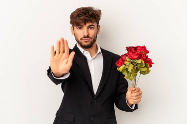 Beyaz arka planda soyutlanmış gül buketi tutan melez genç adam elini uzatıp dur işareti göstererek seni engelliyor..
