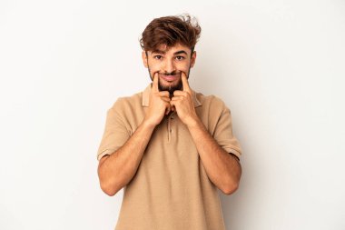 Genç melez adam gri arka planda izole edildi. İki seçenek arasında şüpheye düştü..