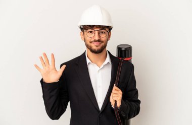 Gri arka planda izole edilmiş kask takan genç mimar beş numarayı parmaklarıyla gülümsüyor..