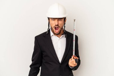 Kask takan ve takan genç bir mimar gri arka planda izole edilmiş bir taksimetre tutuyor. Çok sinirli ve agresif çığlıklar atıyor..