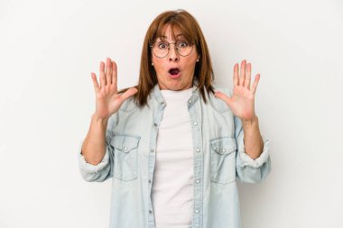 Beyaz arka planda izole edilmiş orta yaşlı beyaz kadın şaşırmış ve şok olmuş..