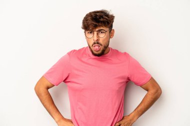 Genç melez adam gri arka planda izole edilmiş komik ve dost canlısı bir dil kullanıyor..