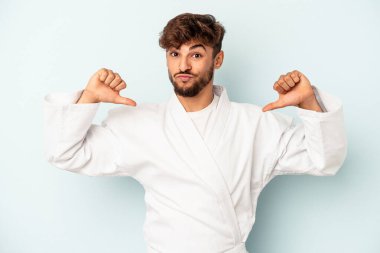 Mavi arka planda karate yapan genç bir ırk gururlu ve kendinden emin, örnek olarak..