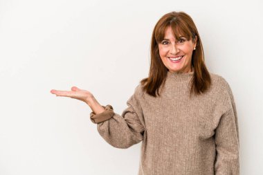 Beyaz arka planda izole edilmiş orta yaşlı beyaz kadın bir palmiye üzerinde fotokopi alanı ve belinde başka bir el tutuyor..