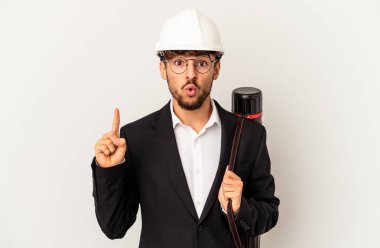 Gri arka planda izole edilmiş bir kask takan genç mimar harika bir fikre sahip, yaratıcılık kavramı..