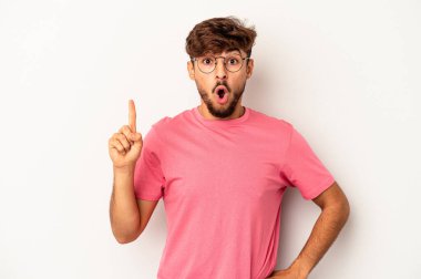 Genç melez adam, gri arka planda izole edilmiş, ağzı açık, üst tarafı işaret ediyor..