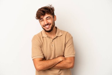 Genç melez adam gri arka planda izole edilmiş gülüyor ve eğleniyor..