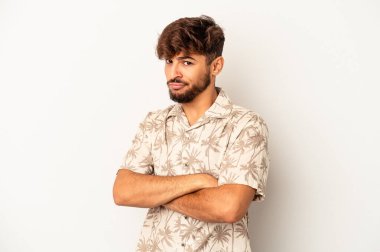 Genç melez adam gri arka planda izole edilmiş. Kameraya alaycı bir ifadeyle bakıyor..