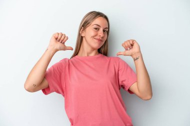 Mavi arka planda izole genç beyaz kadın gururlu ve kendinden emin hissediyor, örnek olarak..