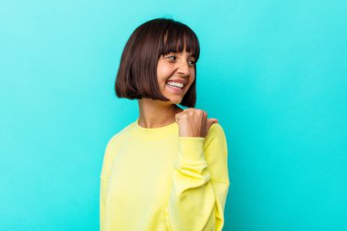 Genç melez kadın mavi arka planda izole edilmiş başparmak uzakta, gülen ve kaygısız.