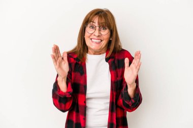 Beyaz arka planda izole edilmiş orta yaşlı beyaz kadın kahkahalarla gülüyor elini göğsüne koyuyor..