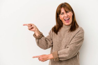 Beyaz arka planda izole edilmiş orta yaşlı beyaz kadın işaret parmağıyla fotokopi alanını işaret ederek heyecan ve arzusunu ifade ediyor..