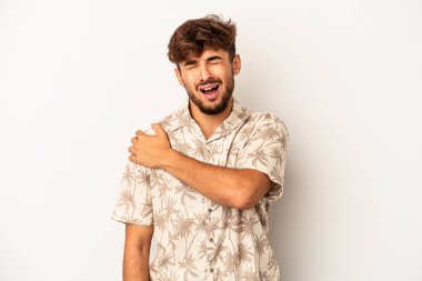 Genç melez adam, gri arka planda izole edilmiş, omuz ağrısı çekiyor..