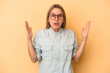 Sarı arka planda izole edilmiş genç beyaz bir kadının bir fikri var, ilham verici bir kavram..