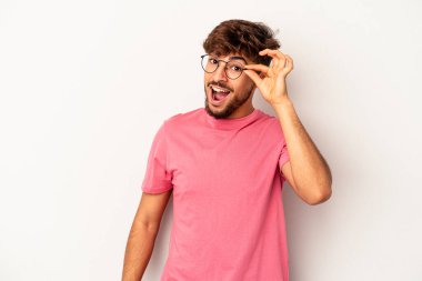 Genç melez adam, gri arka planda izole edildi. Heyecanlı görünüyor..