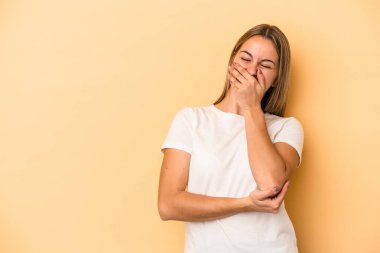 Sarı arka planda izole edilmiş genç beyaz kadın gülüyor, kaygısız, doğal duygu..