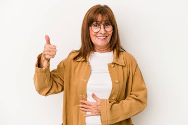 Beyaz arka planda izole edilmiş orta yaşlı beyaz kadın karnına dokunuyor, nazikçe gülümsüyor, yemek yiyor ve tatmin oluyor..