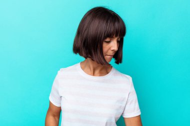 Mavi arka planda izole edilmiş genç melez kadın şans getirsin diye dua ediyor.