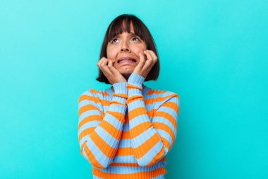 Genç melez kadın, mavi arka planda yalnız başına sızlanıyor ve ağlıyordu..